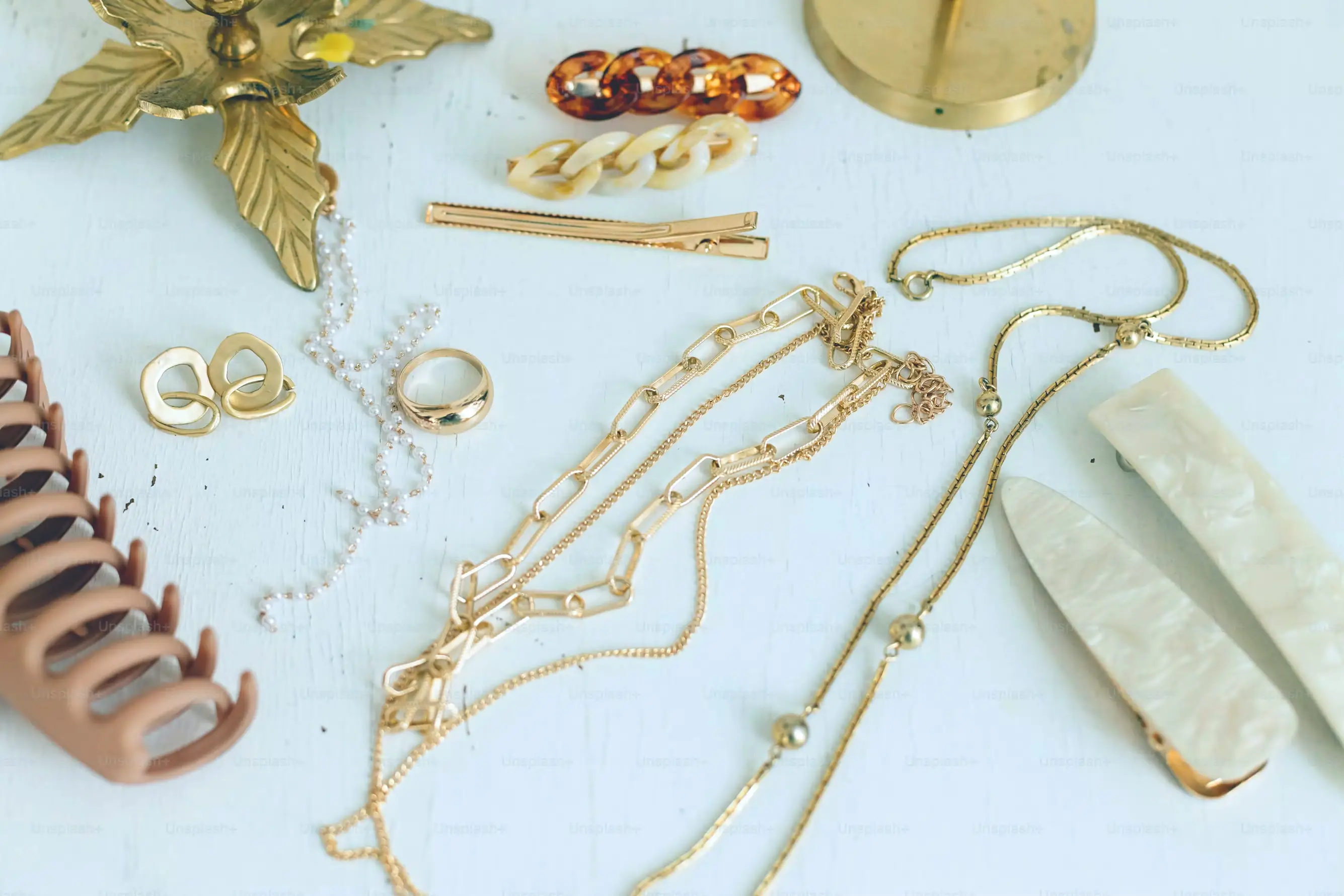 Joyería de oro y accesorios para el pelo sobre una superficie de madera
